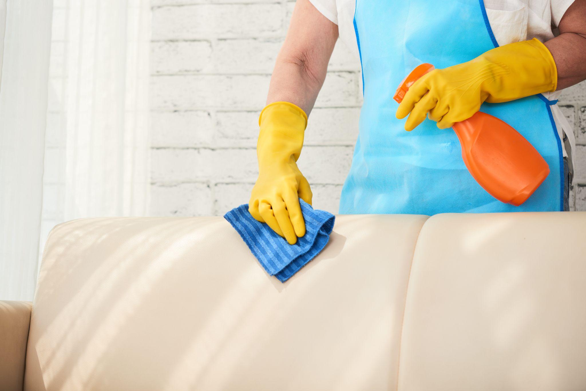 Man cleaning a leather sofa